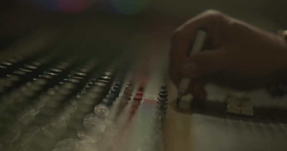 A hand writes something on a piece of tape