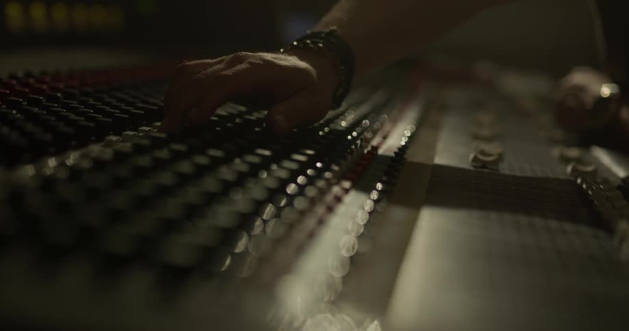 Man adjusts switches on music board