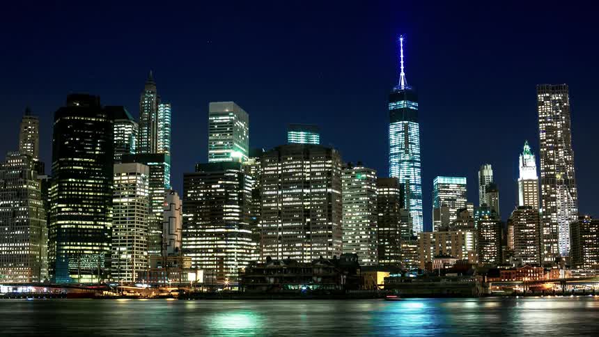 Fast motion of city at night with water in foreground
