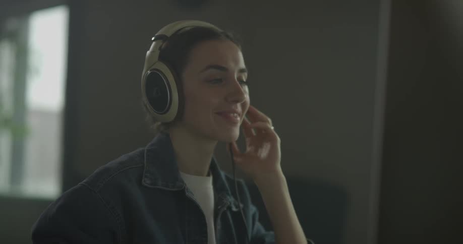 Woman puts on headphones and smiles as she bobs her head