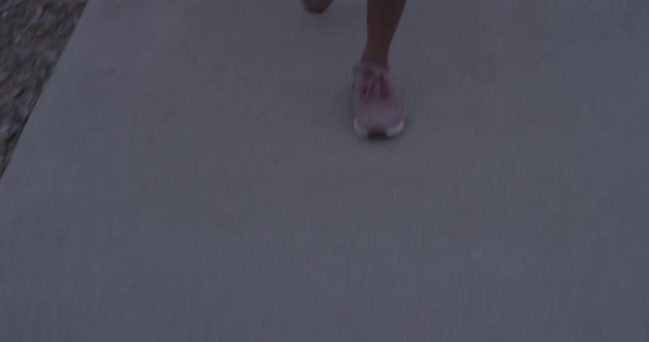 Pink shoes briskly walking down the sidewalk