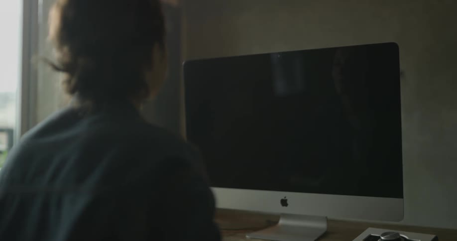 Woman sitting at desk in front of computer