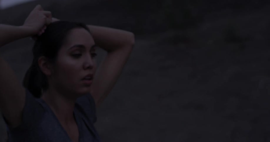 Woman walking down a trail with her hands above her head
