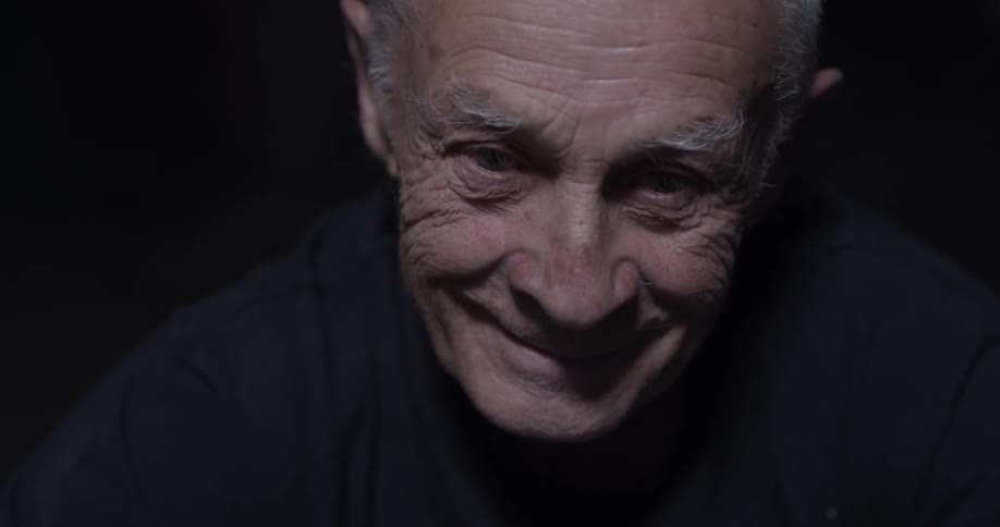 Elderly man looks up with a big smile