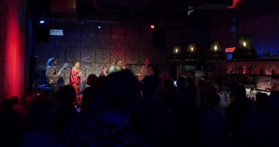 A band plays a concert in a darkened venue
