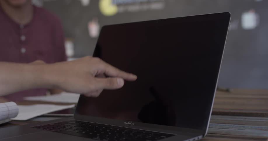 Something is pointed out on a laptop screen