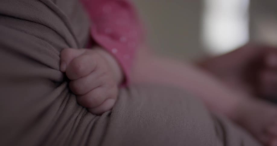 A baby sleeps on a woman's chest