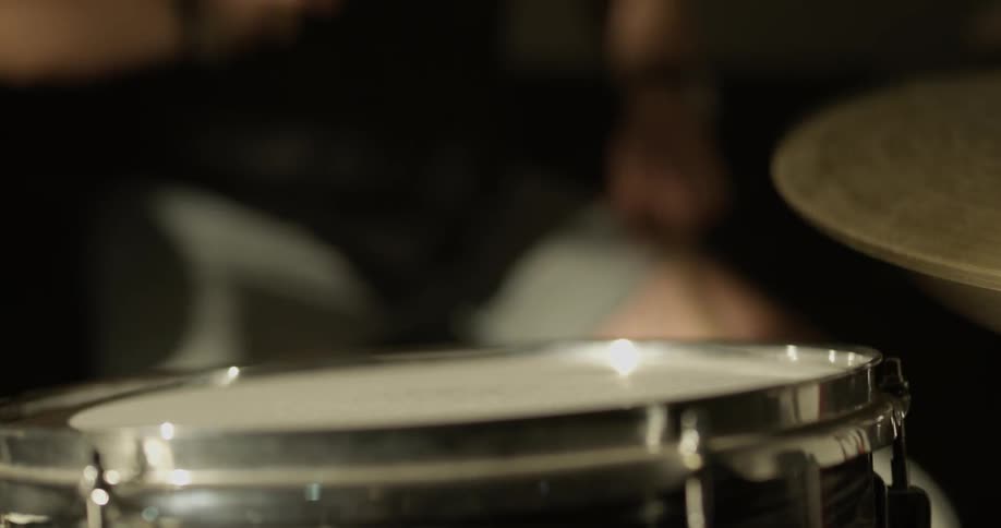 Man hits cymbals and snare drum