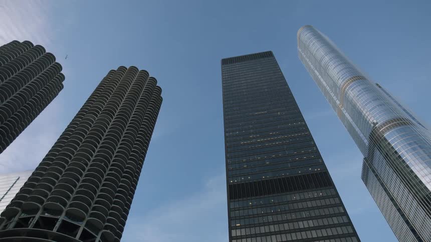 Looking up at large skyscrapers in a blue sky