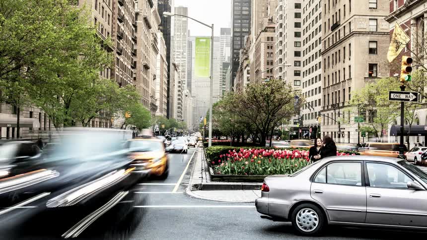 Cars stop and go at a busy intersection in the middle of the city