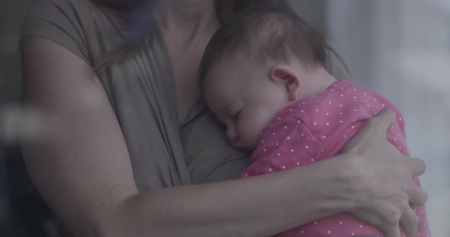 Woman holds baby with pink shirt on