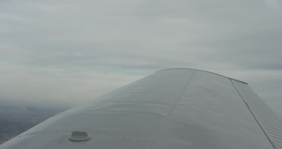 The ground can be seen beyond the airplane wing