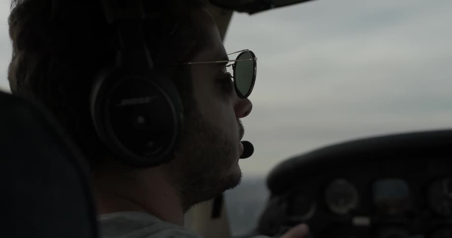A man sits in the cockpit of a plane that he's piloting
