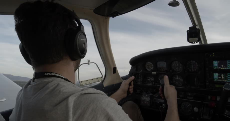 Pilot speaks into radio microphone while flying airplane in the afternoon skies