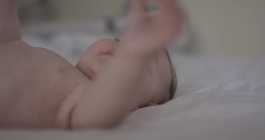 Baby looks around and sucks on hand