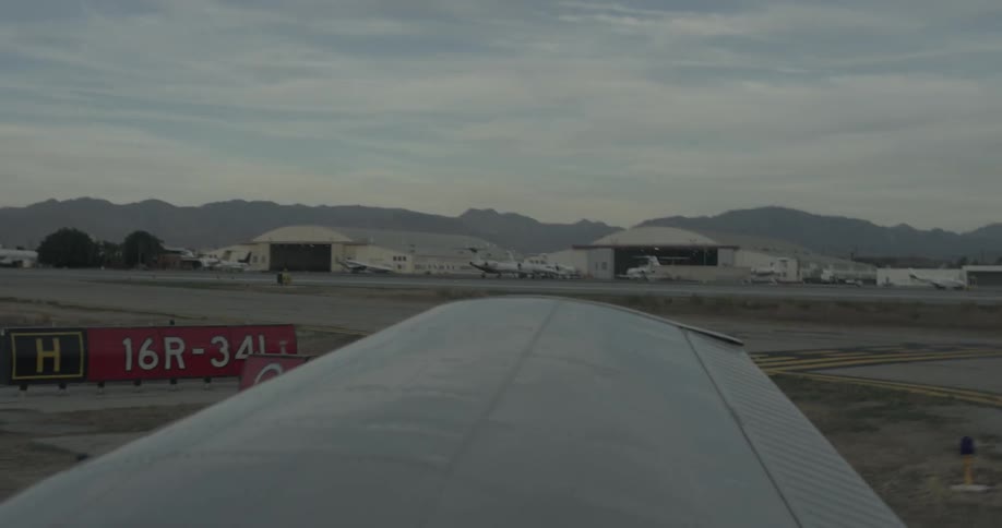 Small plane taxis around a corner at an airfield