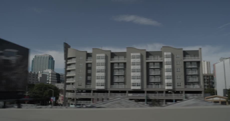 From a highway, passing buildings in the downtown area of a city