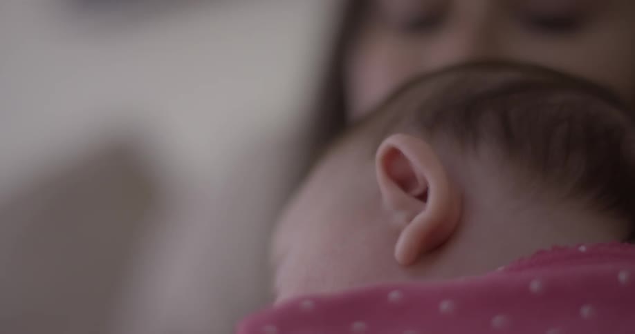 Baby sleeps soundly while held by woman