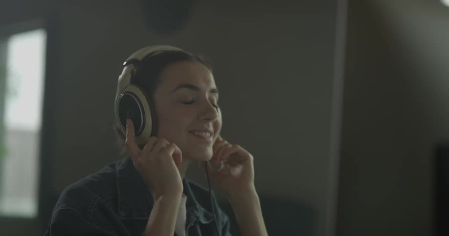 Woman putting on headphones at a computer