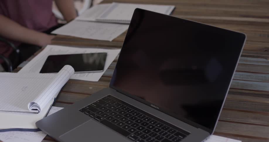 Man reaches out and presses finger against laptop screen