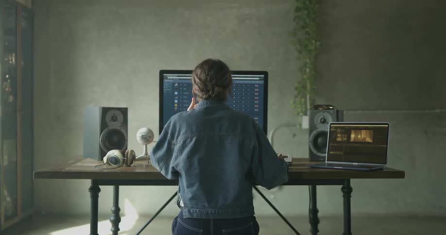 A person sitting a desk looking at a computer monitor