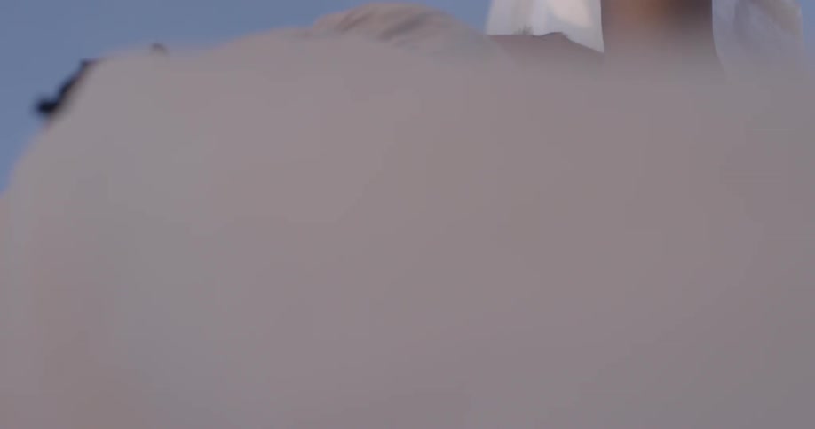 Woman raises white cloth to the sky