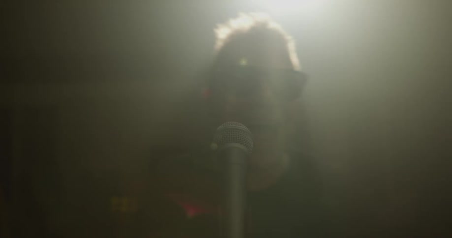 Man approaches microphone and sings