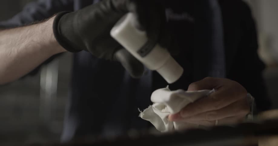 A person shaking a paint bottle and pouring some out