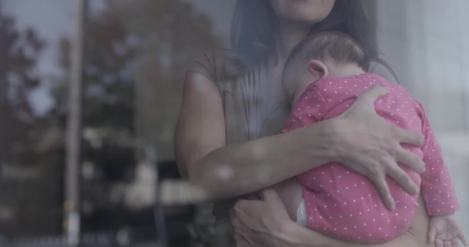 An infant sleeping on a woman's chest