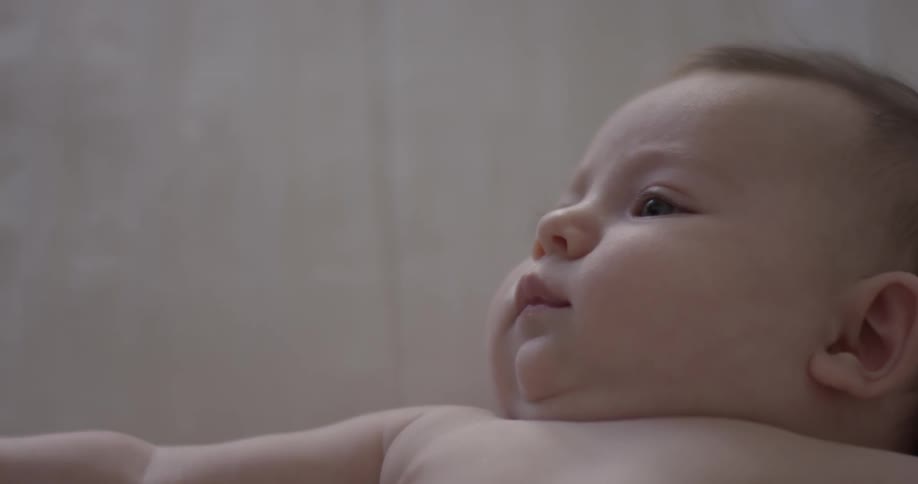 Close up of baby lying on back