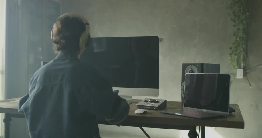 Female with headphones uses her computer