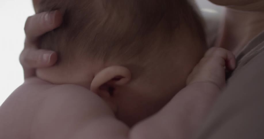 Person clutches baby into chest