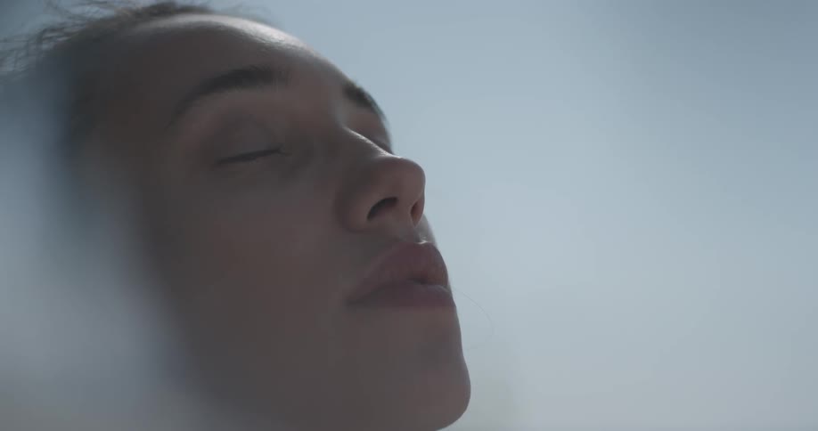 Woman closes her eyes outside
