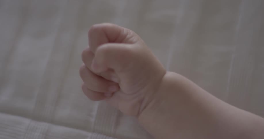 A baby clenches its fist