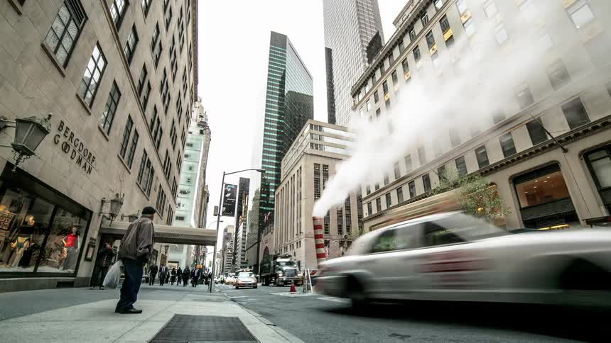 A busy city street with cars and pedestrians passing by