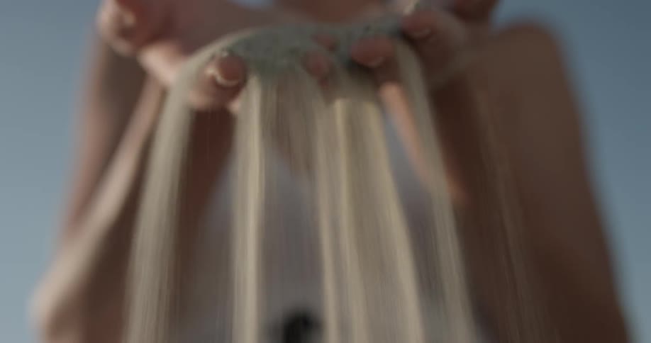 Woman sifting sand between her fingers