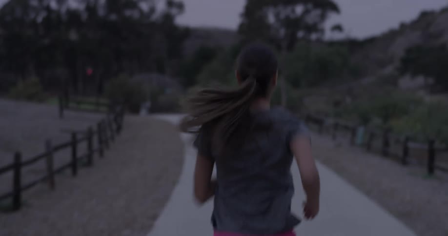 Woman jogs along a cemented road