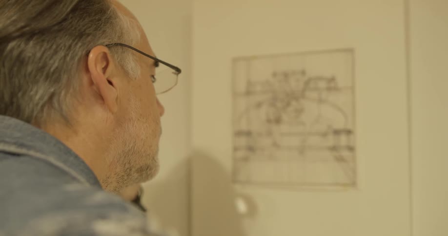 A man looks at a picture on the wall