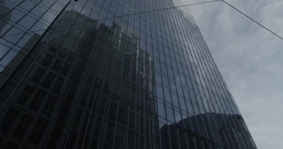 A tall building can be seen in the reflection of another