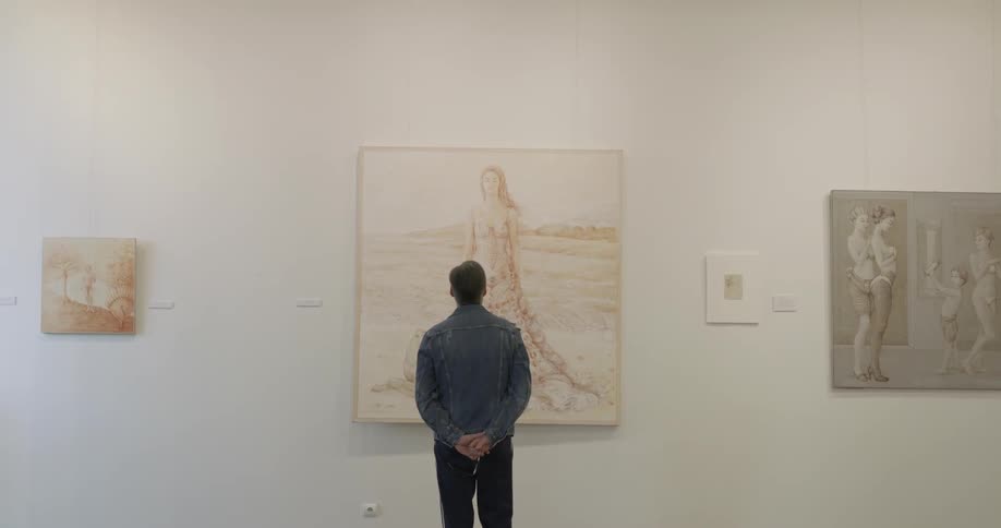 A man walks to a painting and faces it