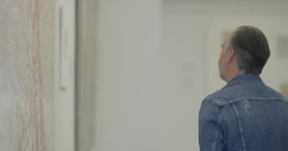 Man views a painting in an art gallery