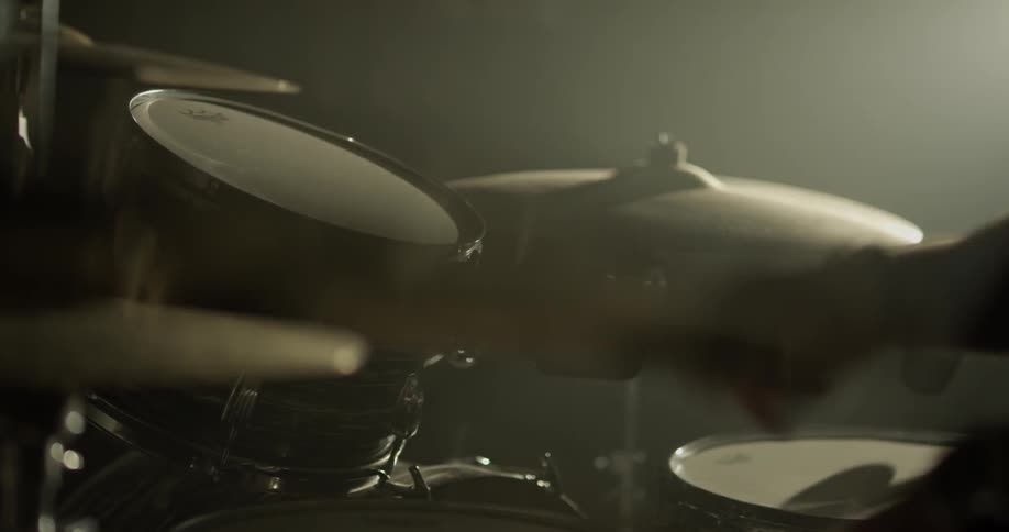 A drummer plays the hi hat and snare drum on a drum set