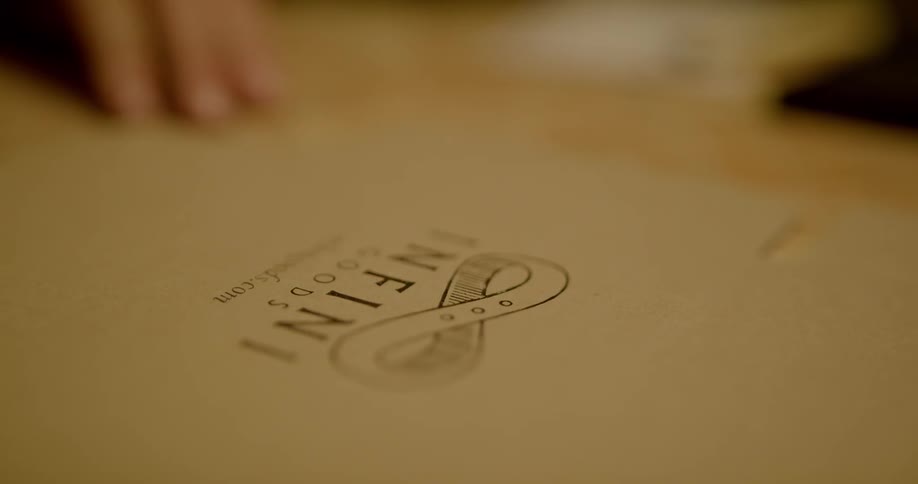 A person that is pressing onto a piece of paper