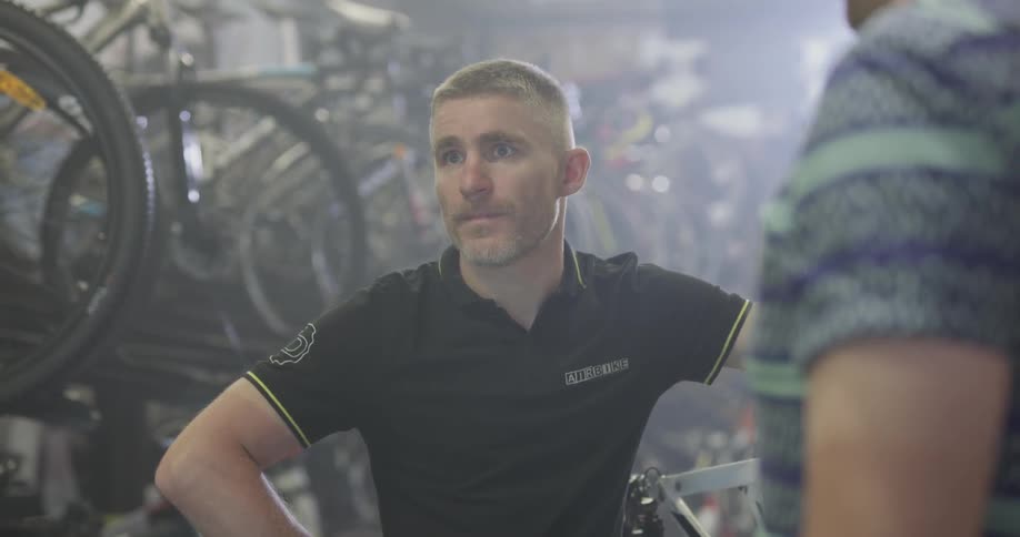 Two men having a conversation in a bike shop