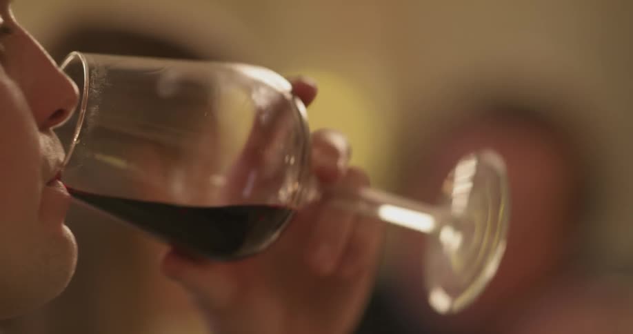 Woman takes a sip of wine at the table