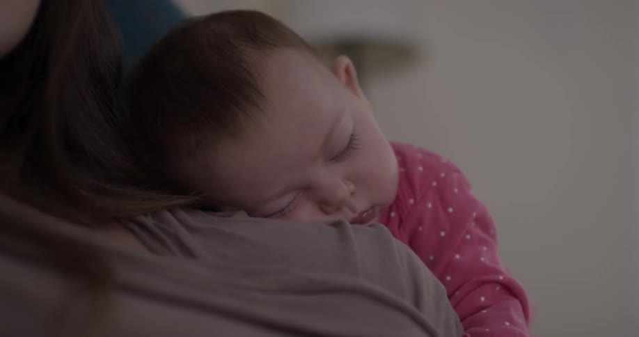 Baby lays on shoulder of person