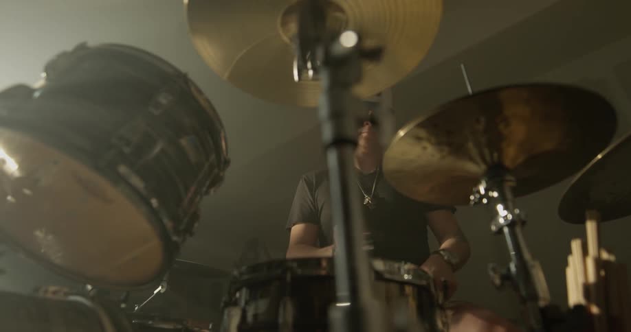 A man in sunglasses plays the drums