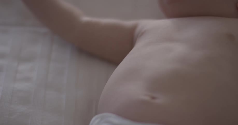 A baby laying on a blanket wriggles around