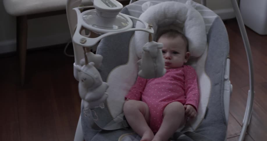 An infant swinging in a baby swing