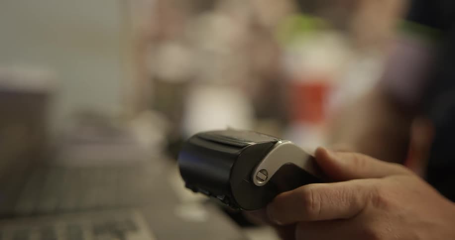 A small credit card machine printing out a receipt